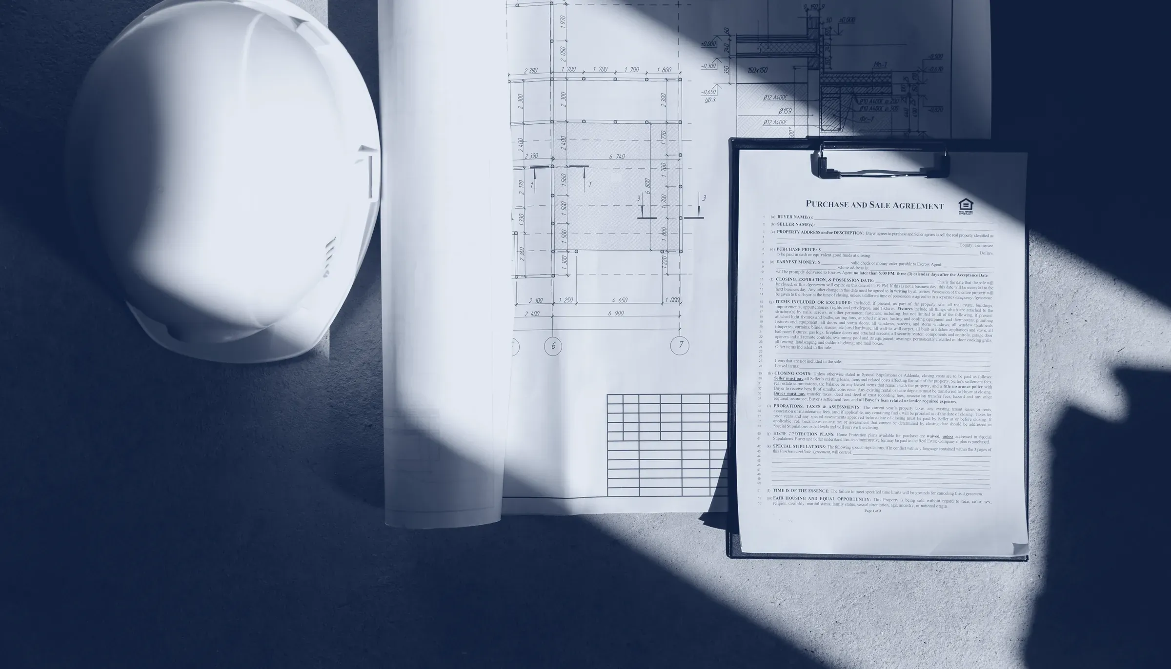 Bauhelm und Baupläne auf dem Tisch